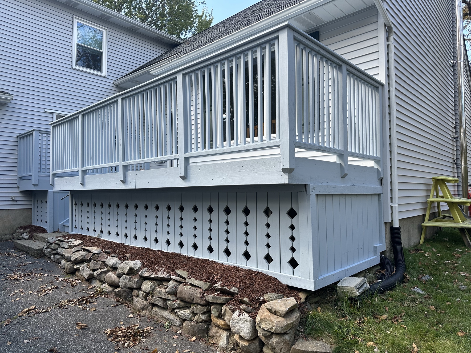 White painted deck with railings and lattice skirt by J&B Painting