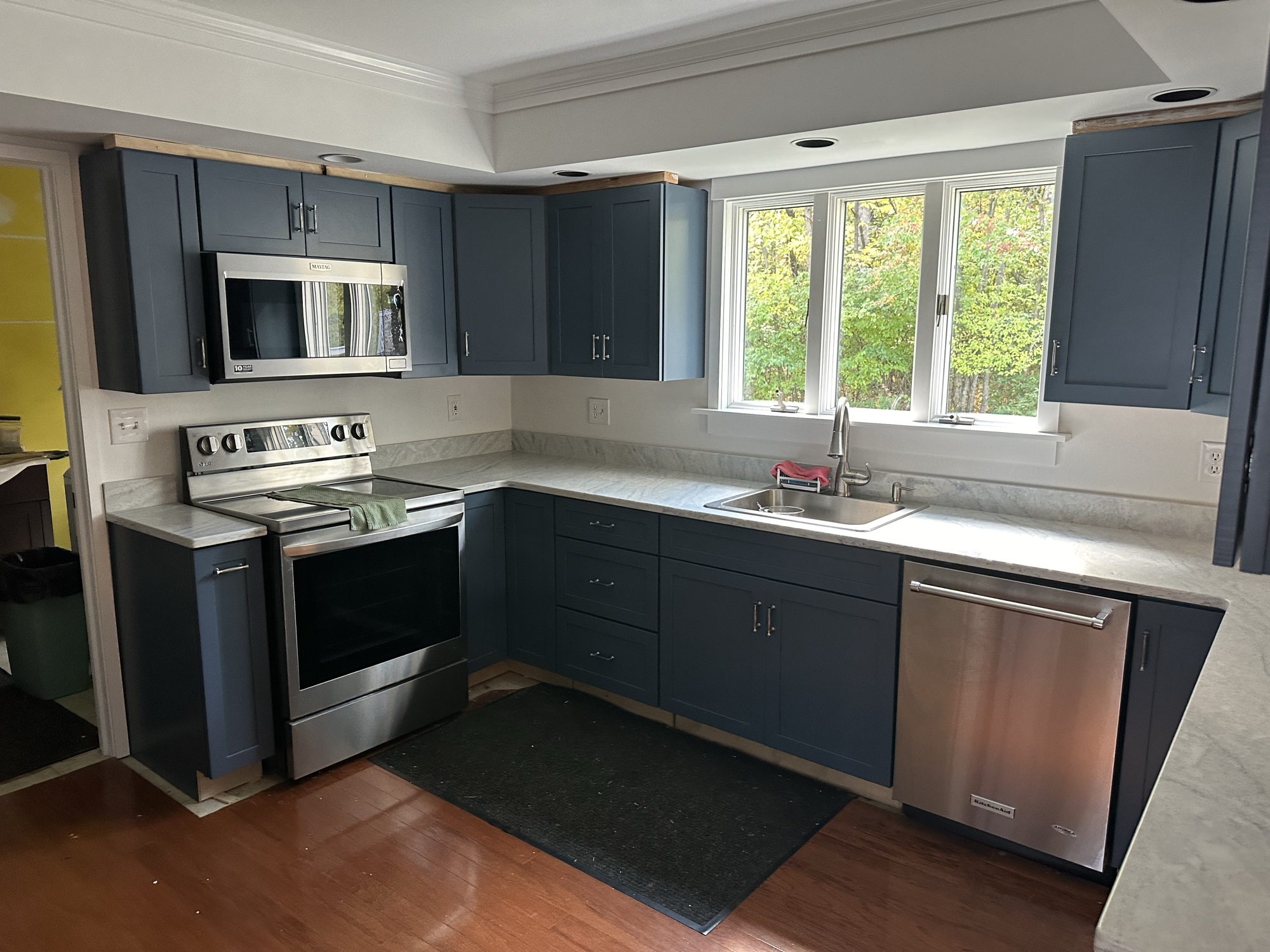 Navy blue kitchen cabinet refinishing with marble countertops by J&B Painting