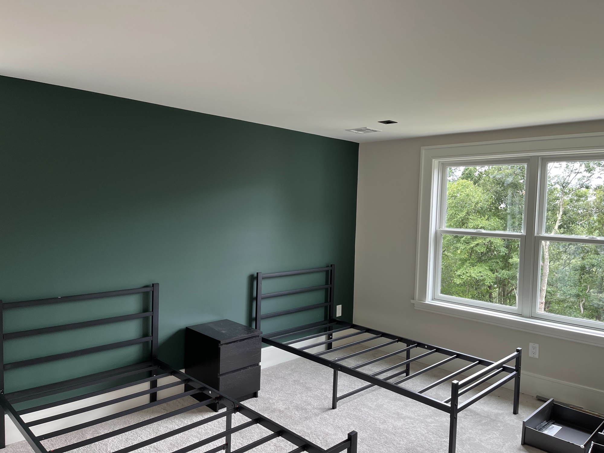 Bedroom with deep green accent wall by J&B Painting