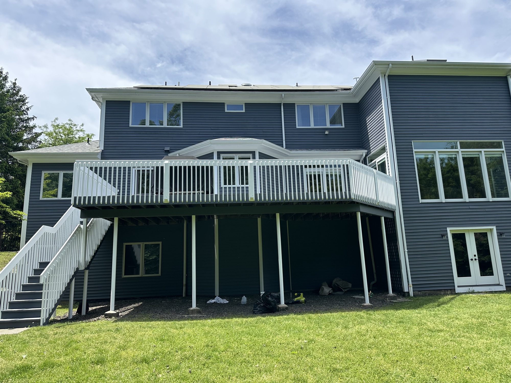 Gray blue home with white deck and railings by J&B Painting
