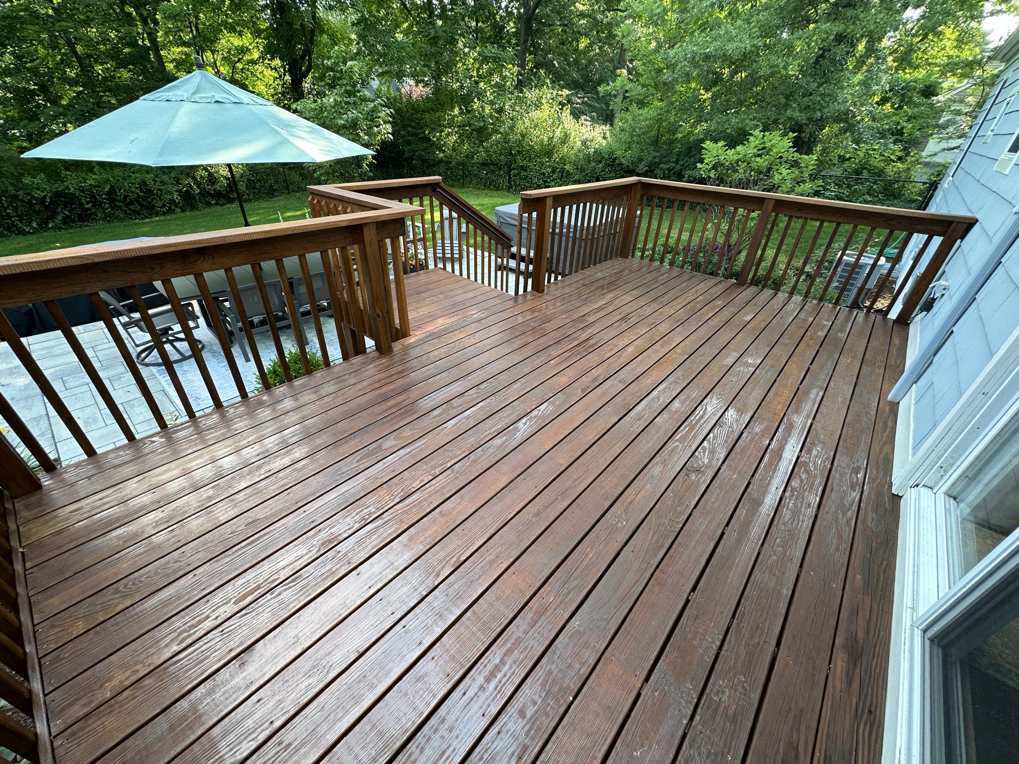 Large stained deck with patio umbrella by J&B Painting