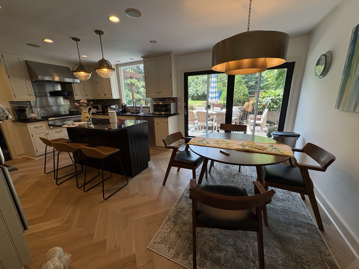 Two-tone kitchen cabinet refinishing - white perimeter and dark island by J&B Painting