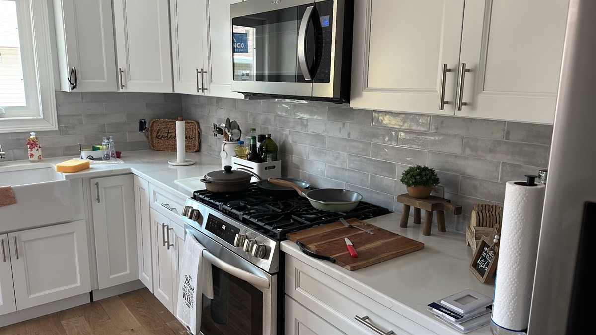 White shaker kitchen cabinets with tile backsplash by J&B Painting