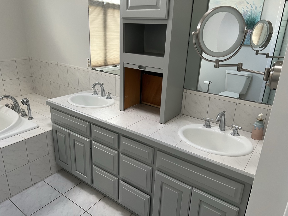Gray bathroom vanity with dual sinks and mirrors by J&B Painting