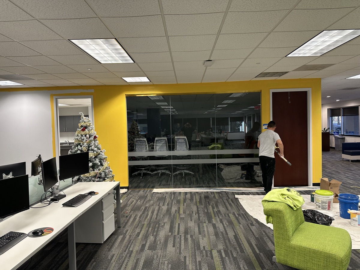 Corporate office yellow accent wall with glass conference room by J&B Painting