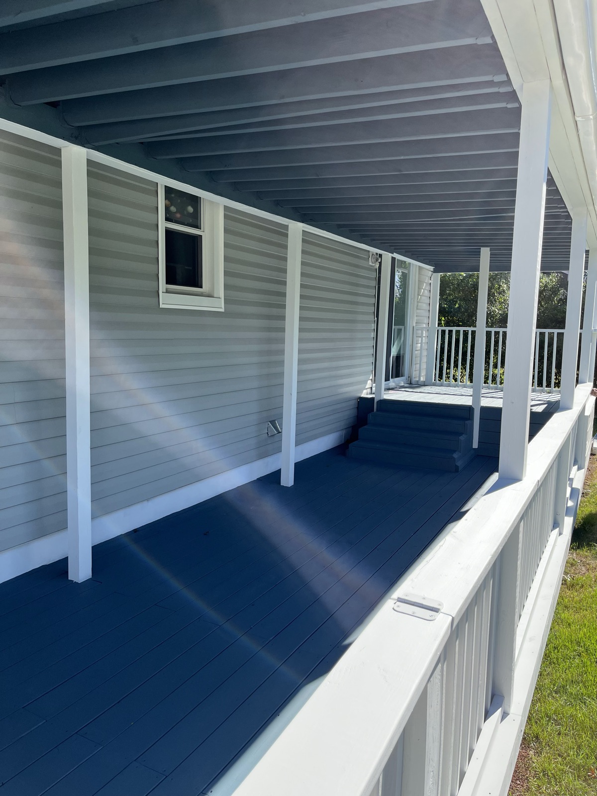 Blue porch floor with white trim and railings by J&B Painting