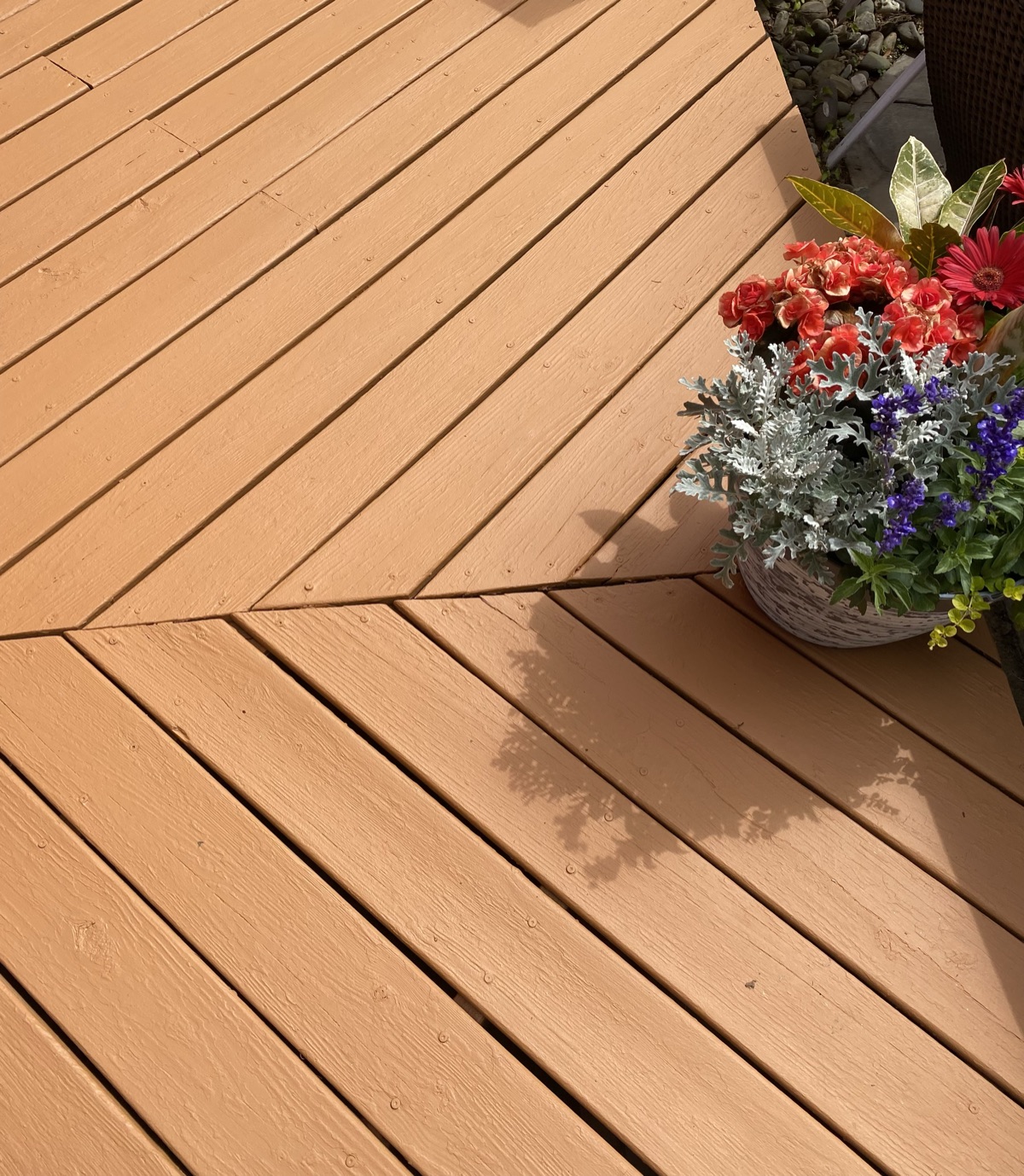 Stained herringbone pattern deck with flower pot by J&B Painting