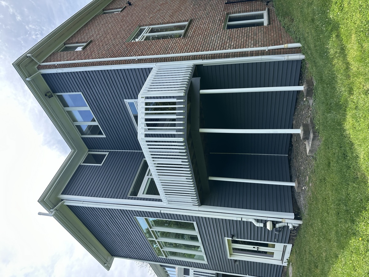 Dark gray home with white painted deck and railings by J&B Painting