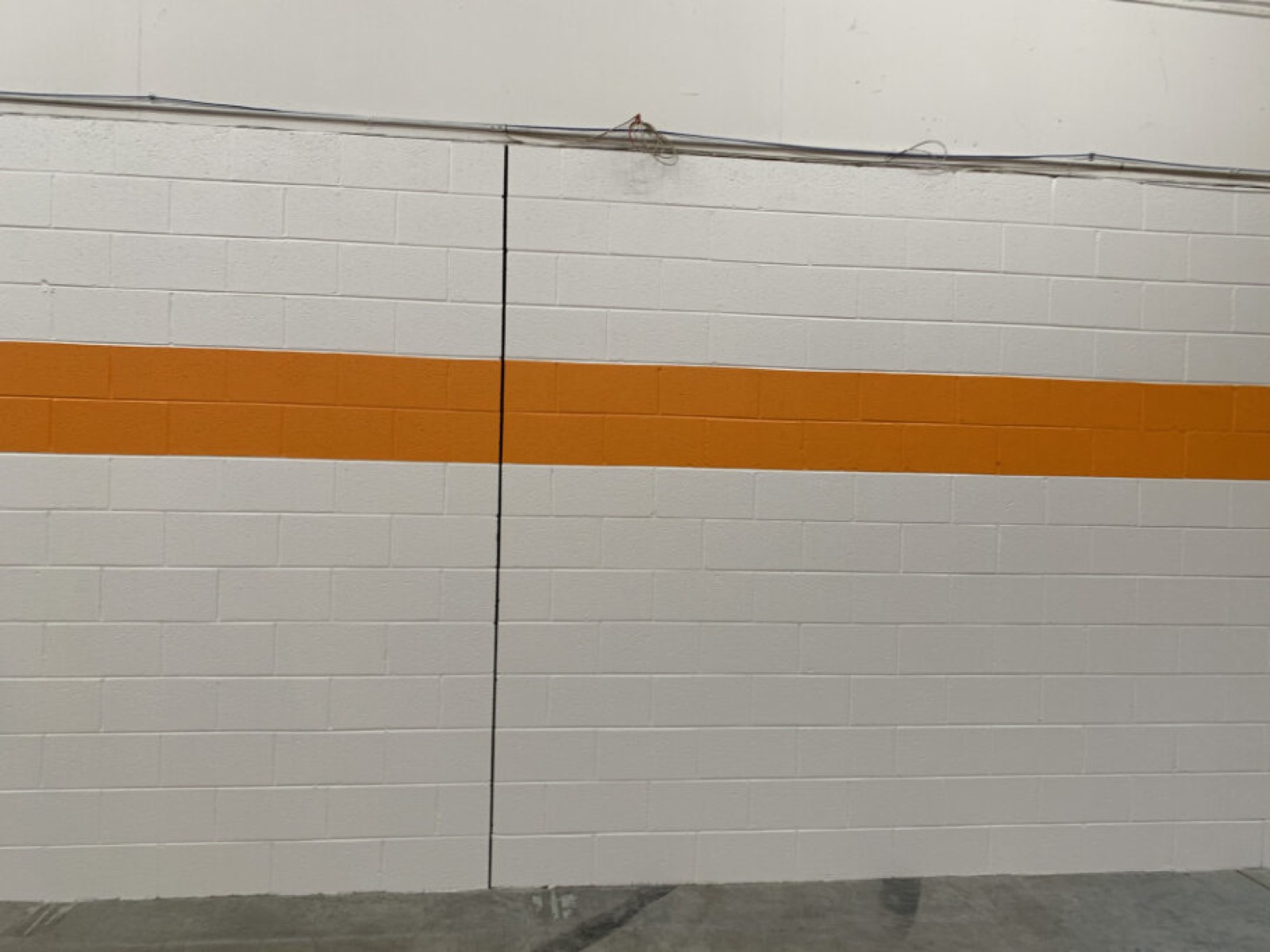 Warehouse interior with orange accent stripe by J&B Painting