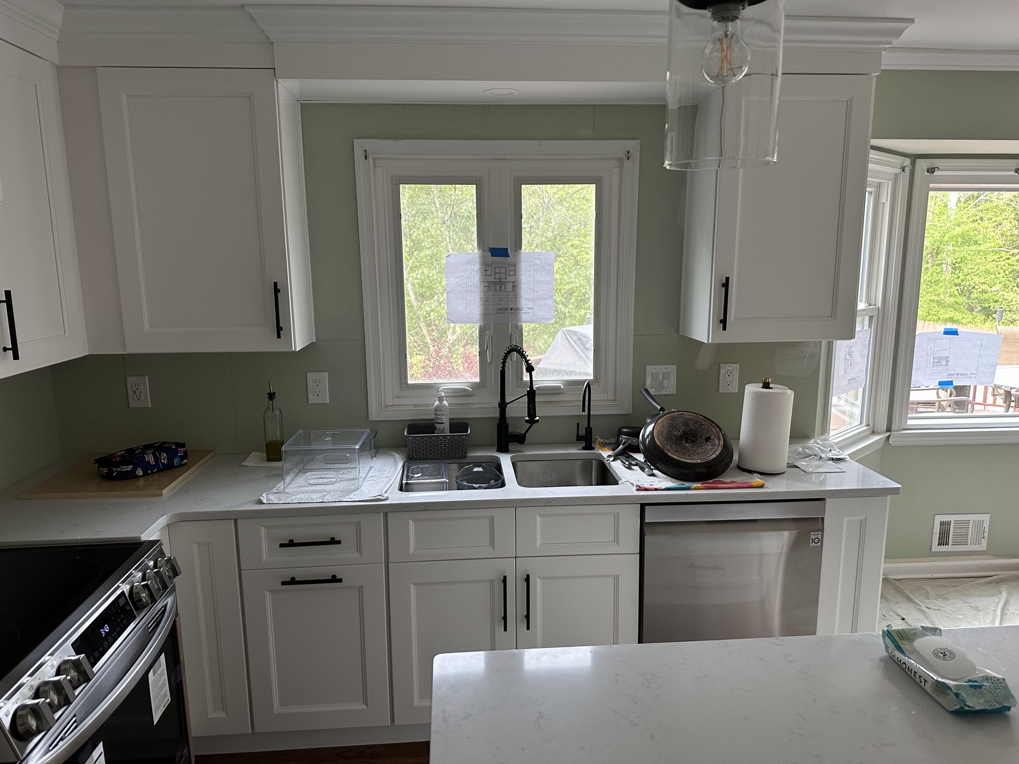 White kitchen cabinets with sage green walls by J&B Painting