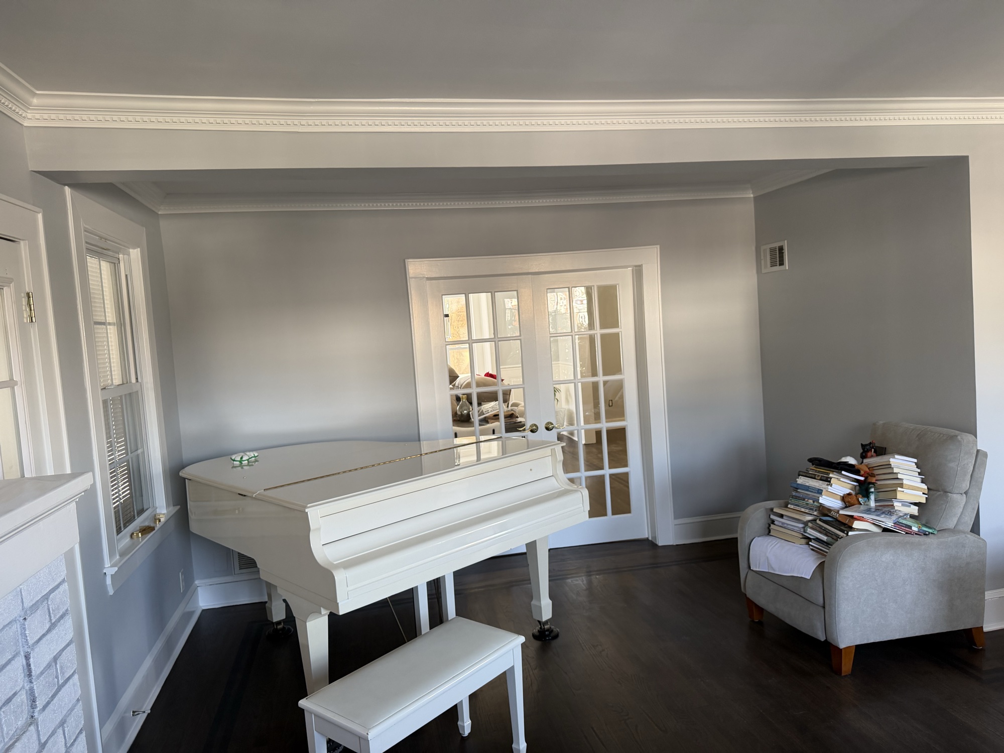 Gray living room with white piano and French doors by J&B Painting